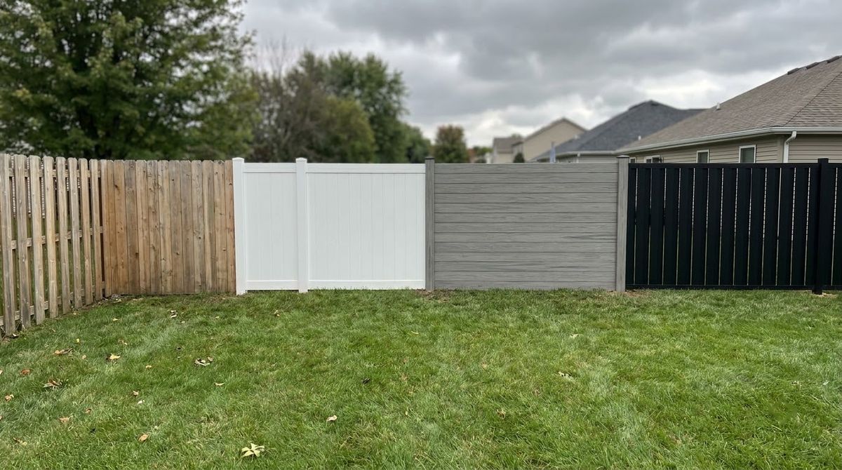 Wood, white vinyl, gray composite and black aluminum privacy fence panels side by side in a yard
