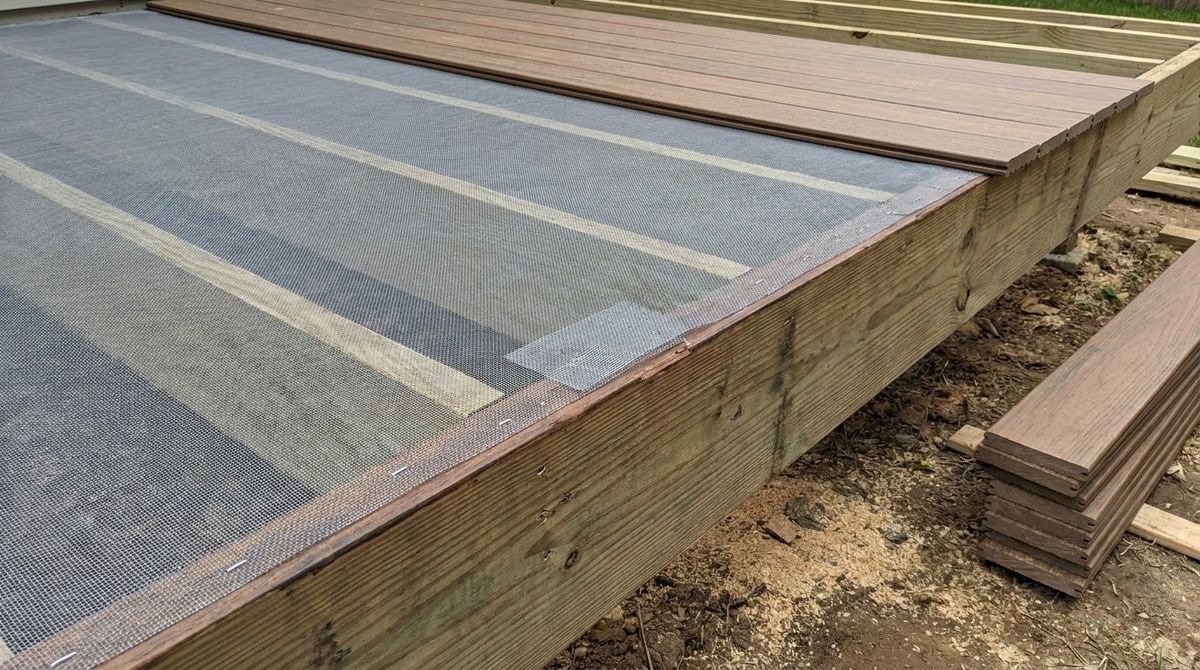 Fiberglass insect screen stapled across deck joists before the deck boards are installed