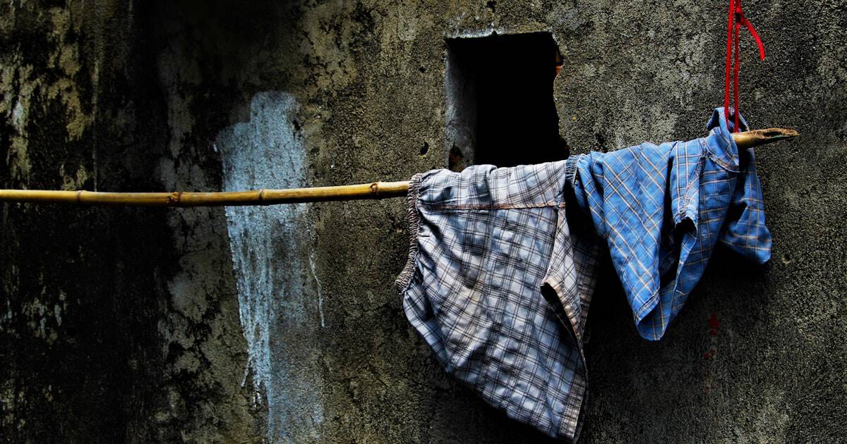 Colorful shirts and shorts hanging to dry outside a laundry shop in Hoi An, Vietnam