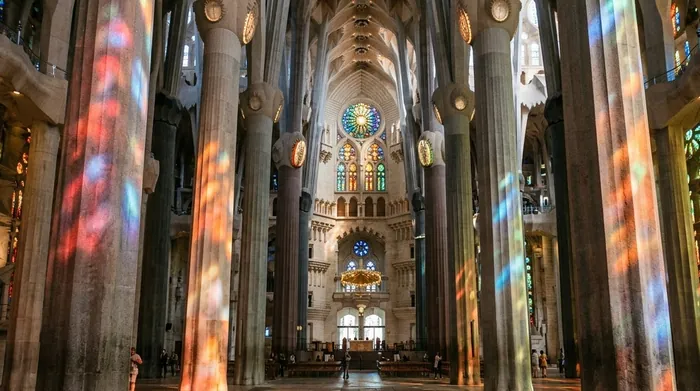 Illustration of stained-glass light on tall stone columns inside a basilica