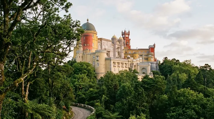Illustration of a colourful towered palace above the forest in Sintra