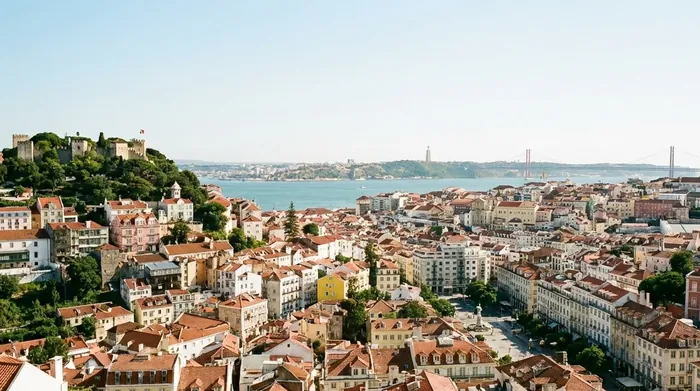 Illustration of Lisbon rooftops and the Tagus under a clear June sky