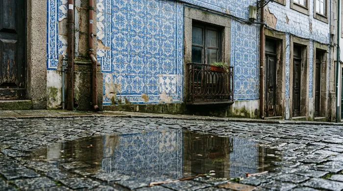 Illustration of a tiled Porto facade reflected in a puddle after rain