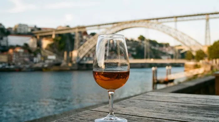 Illustration of a glass of port with the Douro river behind