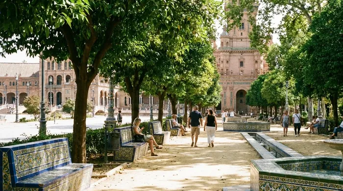 Illustration of a shaded park path with tiled benches in Seville