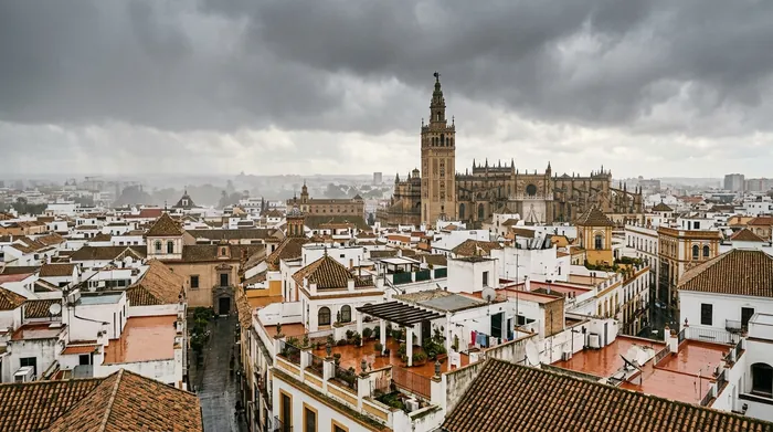 Illustration of Seville rooftops under winter rain clouds