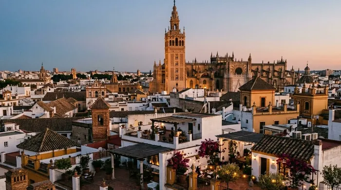 Illustration of rooftop terraces in Seville's old city at dusk