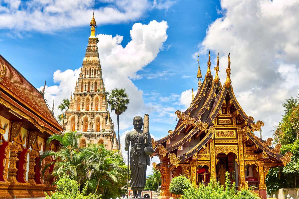 Golden Thai Buddhist temple spires glowing against a clear blue sky