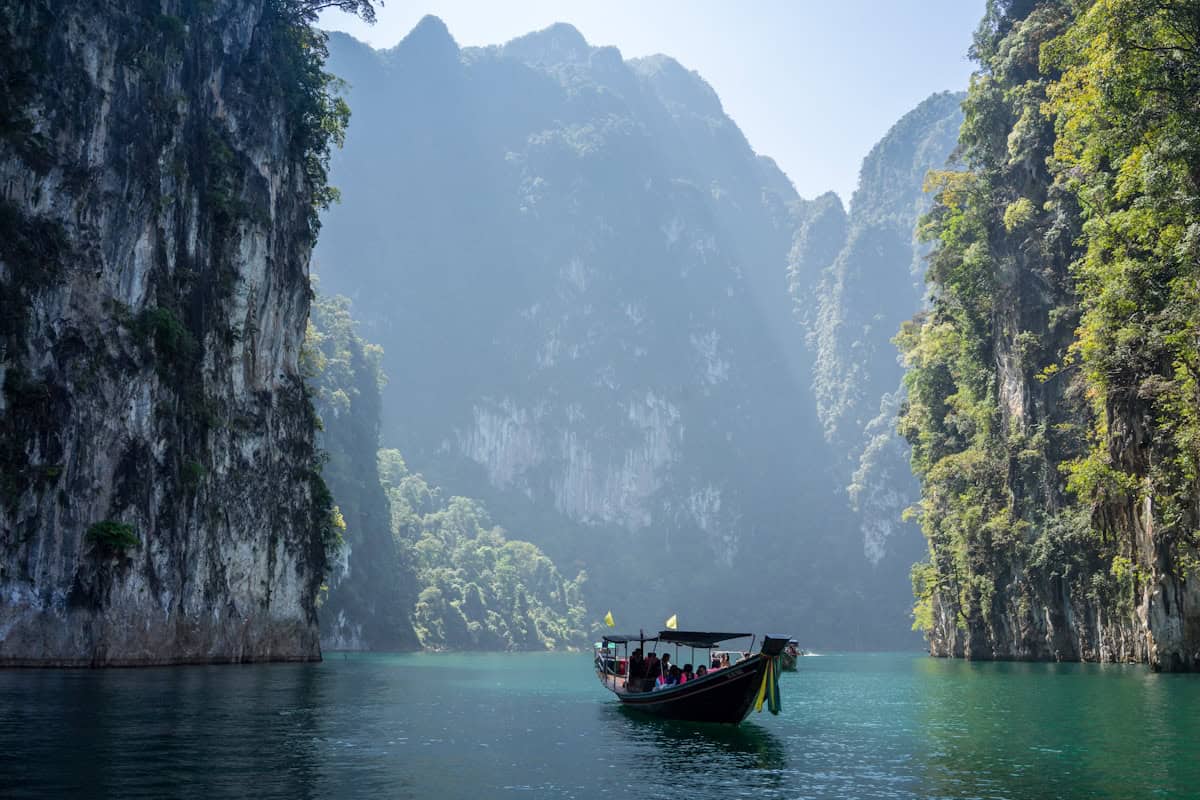 Traditional Thai longtail boat floating on calm turquoise waters near limestone karst islands