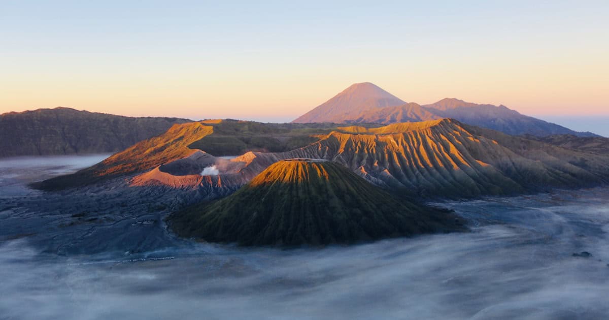 Calm turquoise water at a Bali beach with traditional fishing boats showing where to stay in Bali for couples and sunset views