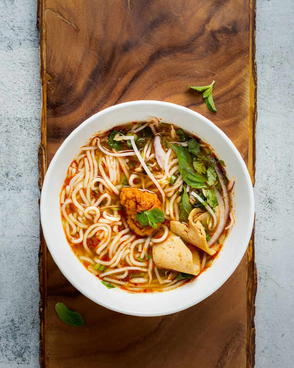 Bowl of phở with fresh herbs and lime on a street stall table — a classic stop on any self-guided saigon food tour in Ho Chi Minh City