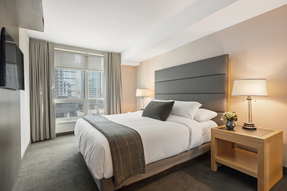 Minimalist bedroom with platform bed, neutral linen duvet, and uncluttered wooden nightstand