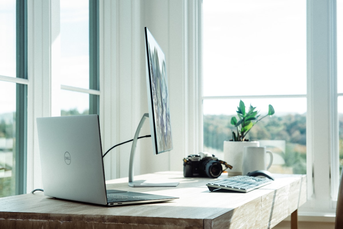 Minimalist home office with white desk, single monitor, and cable-free surface