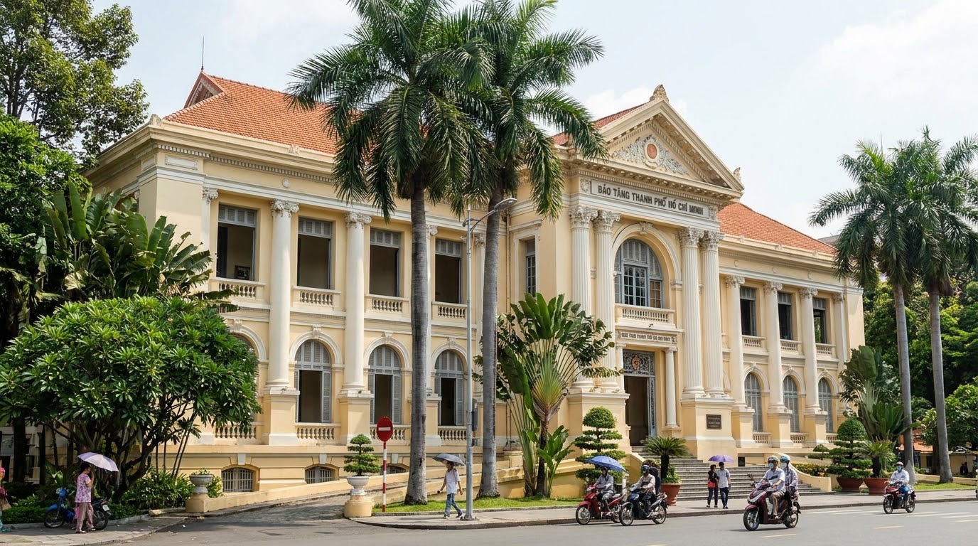 Exterior facade of the Ho Chi Minh City Museum, a neoclassical yellow French colonial building framed by tropical palms in District 1 Saigon