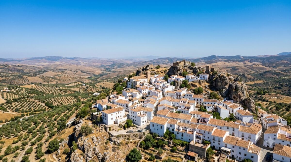 A whitewashed hilltop village in Andalusia surrounded by olive groves
