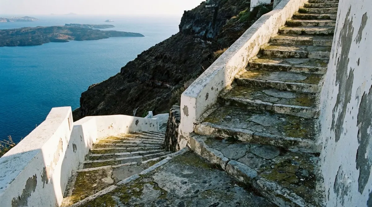 Steep zigzag stone steps climbing the volcanic cliff in Santorini