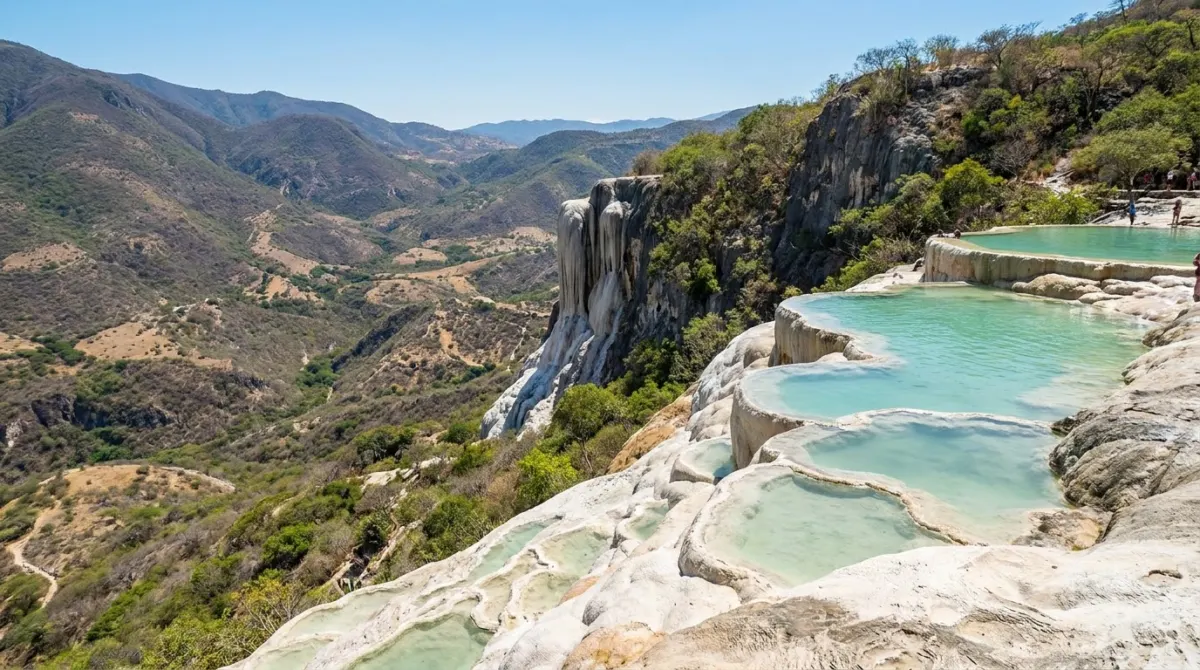 White mineral terraces and a petrified waterfall cliff above a mountain valley, Hierve el Agua, Oaxaca, Mexico