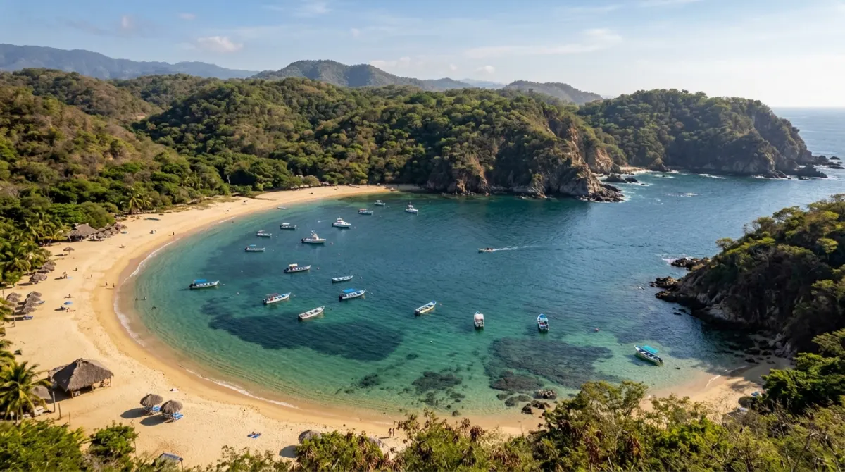 A sheltered horseshoe bay with clear water and small boats, forested hills behind, Huatulco, Oaxaca, Mexico