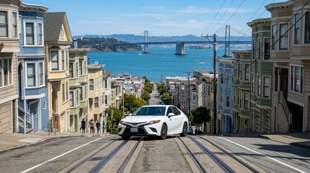 Rental car on a steep San Francisco hill street with the Bay Bridge view