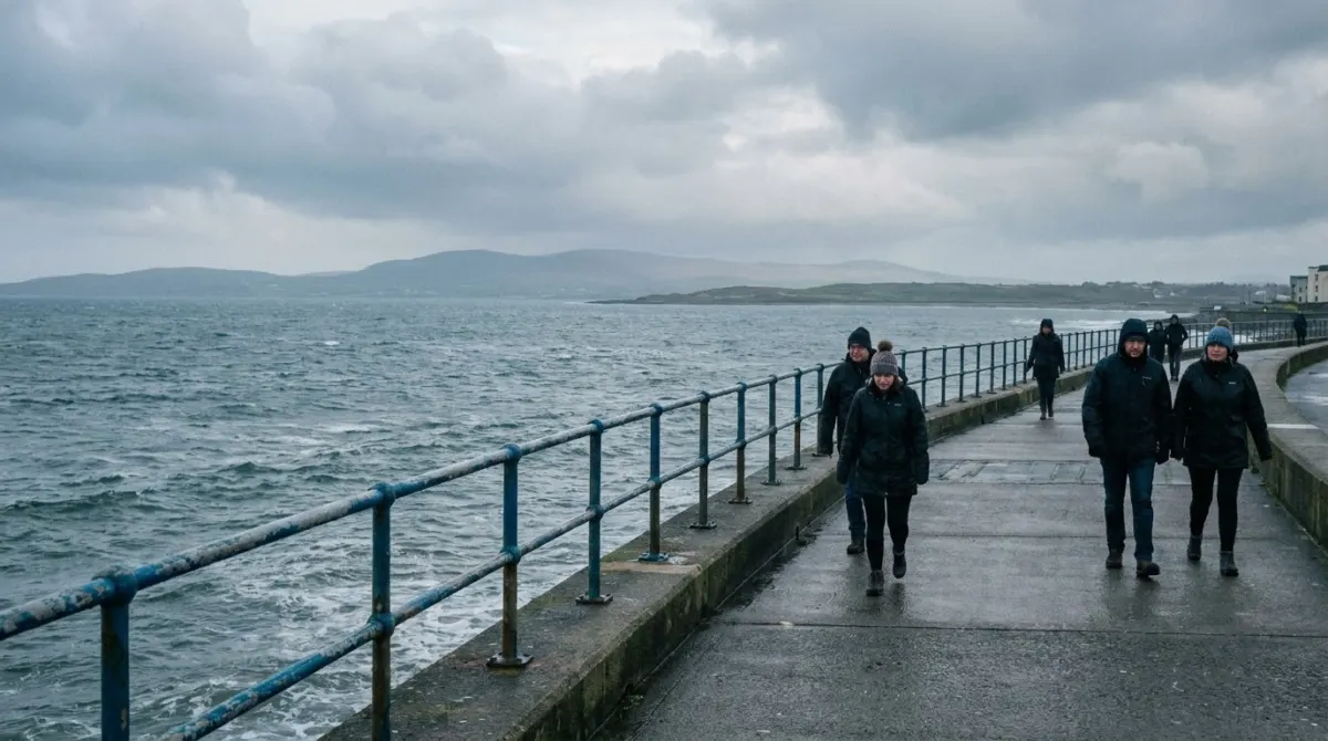 A long seafront promenade with a railing and a wide bay beyond, Salthill, Galway