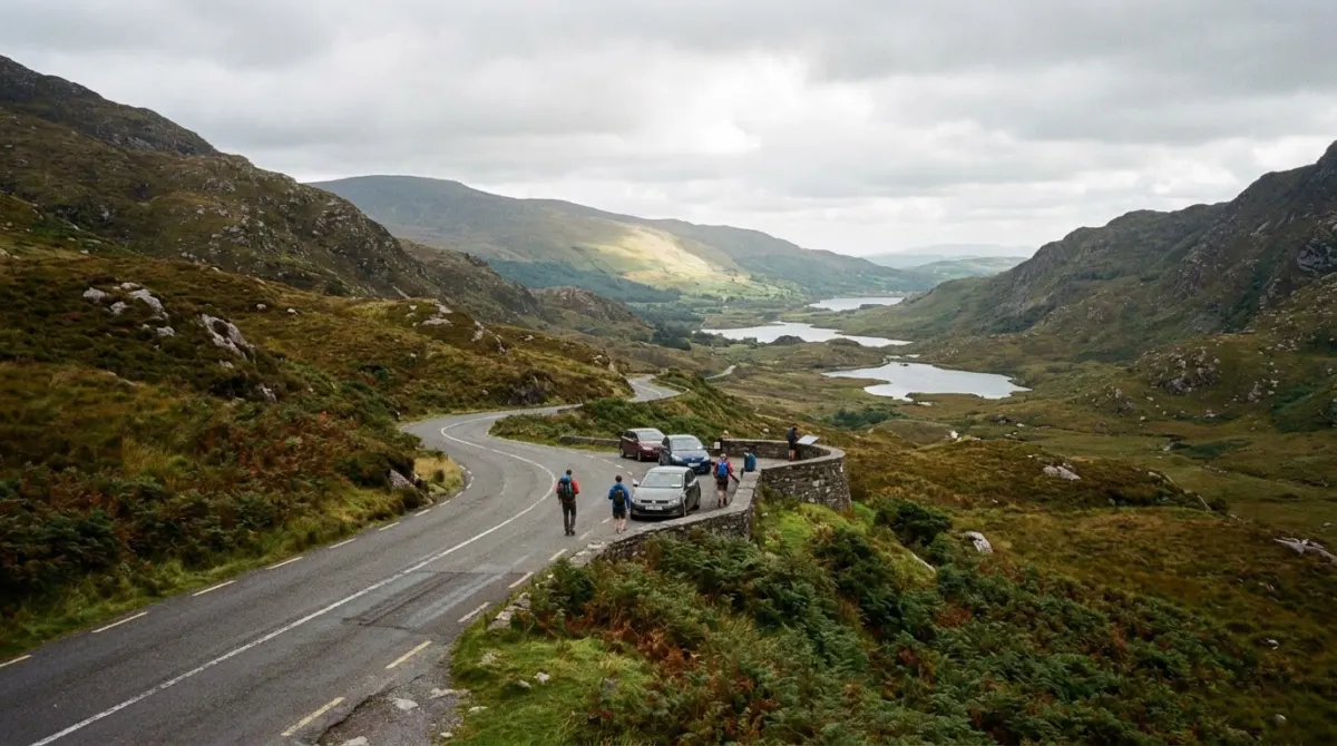 A mountain pass road winding between rocky slopes above lakes, Moll's Gap, County Kerry, Ireland
