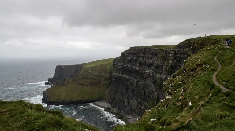 High sea cliffs dropping into the Atlantic under a grey sky, Cliffs of Moher, County Clare, Ireland