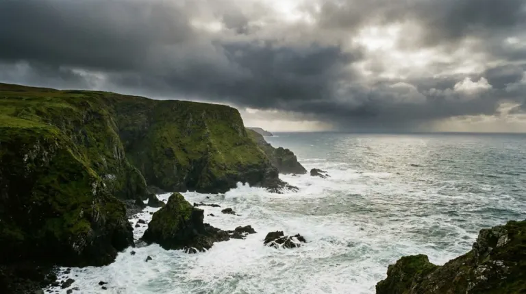 A wild Atlantic coastline with high green cliffs and white surf under heavy cloud, western Ireland