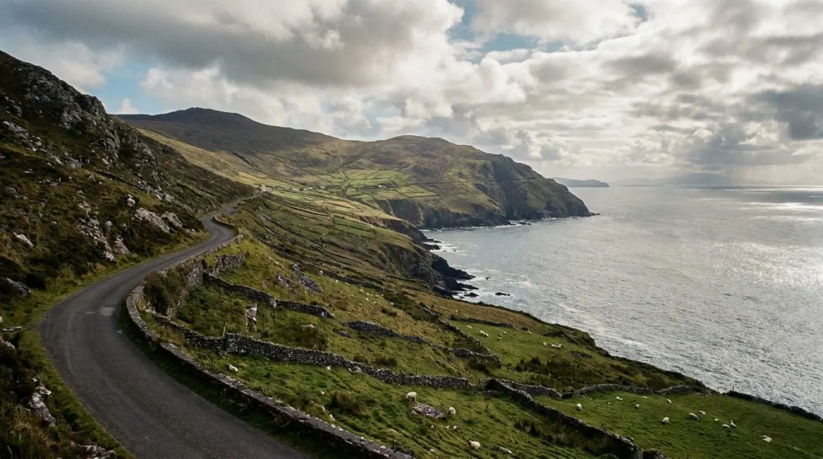 A narrow road along a mountainous peninsula above the sea with small stone-walled fields, County Kerry, Ireland