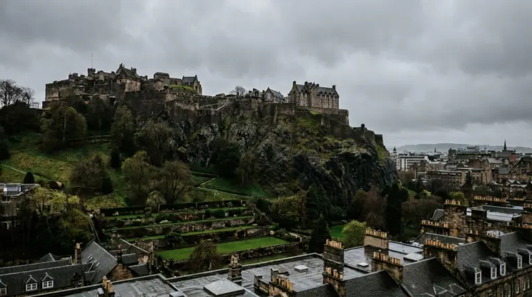A castle on top of a sheer volcanic rock above a city with gardens below, Edinburgh, Scotland