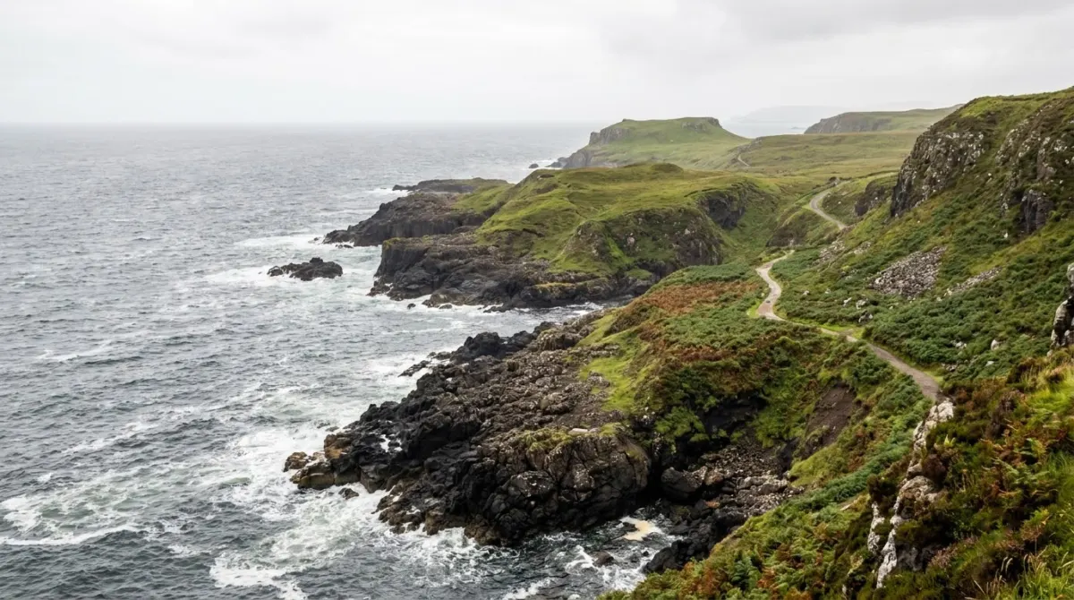 A rocky coastline with sea cliffs and green headlands under a grey sky, Isle of Skye, Scotland