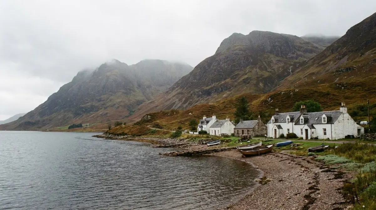 A small village of white houses beside a sea loch with mountains behind, Glencoe, Scotland