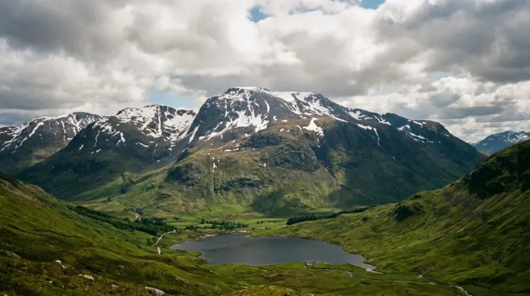 A high mountain with snow patches rising above a glen and a loch, Ben Nevis area, Scotland