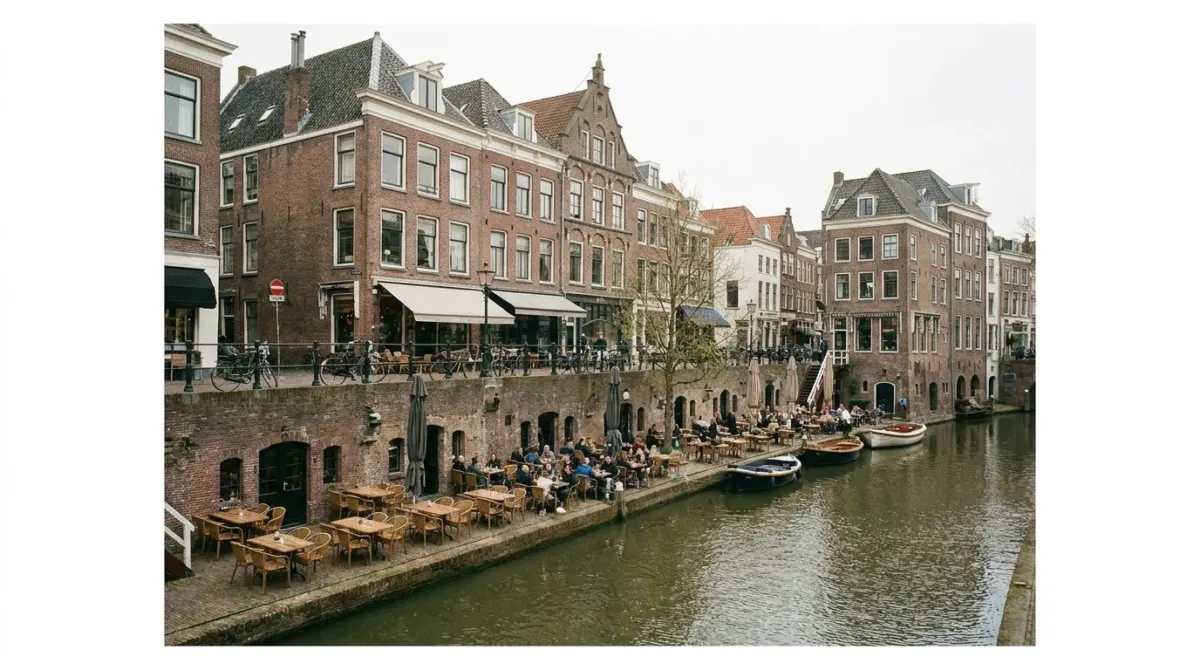 A canal with brick wharves a storey below street level and cafe terraces on the water, Utrecht, Netherlands