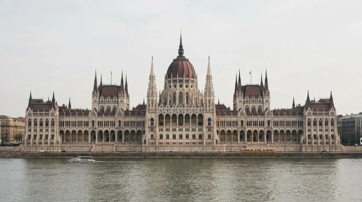 A vast neo-gothic parliament building on a riverbank seen from across the water, Budapest, Hungary