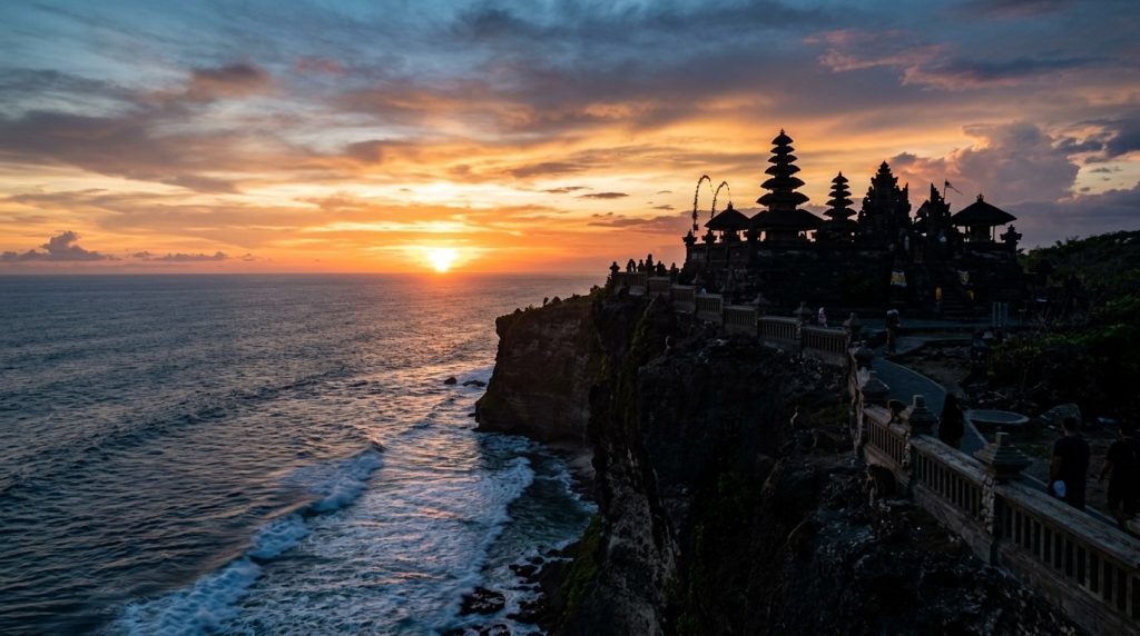 the clifftop silhouette of Uluwatu Temple against the sunset sky