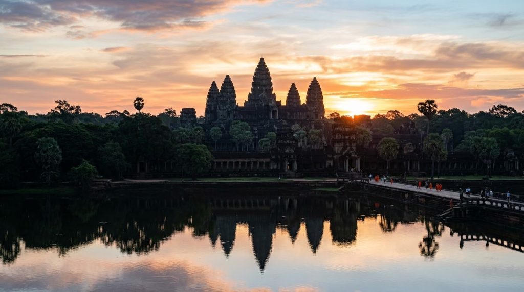 the towers of Angkor Wat rising above the tree line at sunrise
