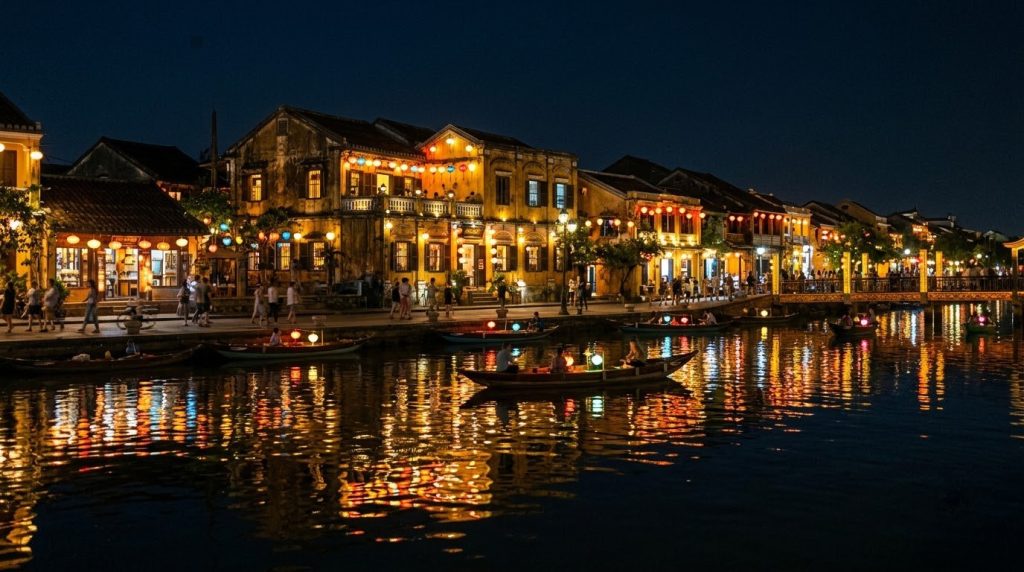Lantern-lit old town buildings reflected in the river in Hoi An