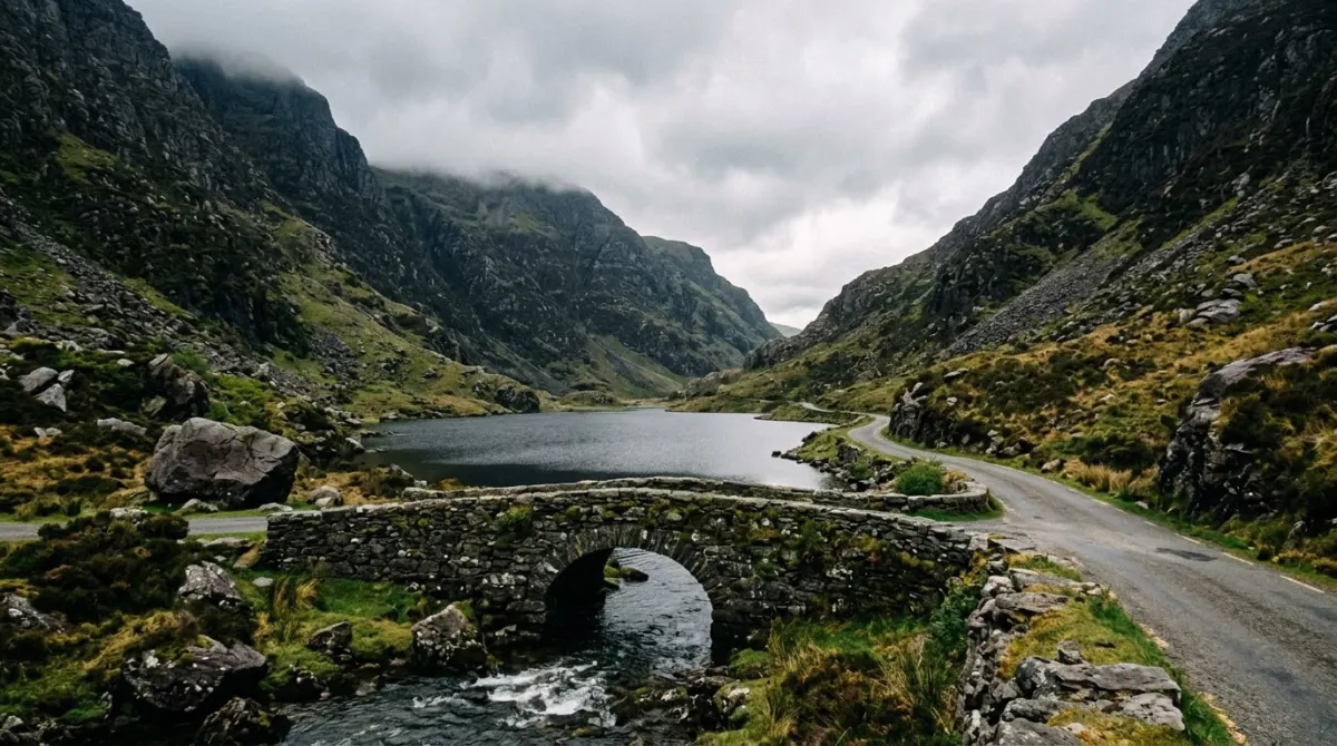 A narrow glacial pass with a small road, a stone bridge and lakes between steep mountains, Gap of Dunloe, County Kerry, Ireland
