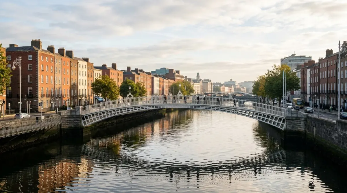 A white cast iron footbridge over a river with Georgian quays in morning light, Dublin, Ireland
