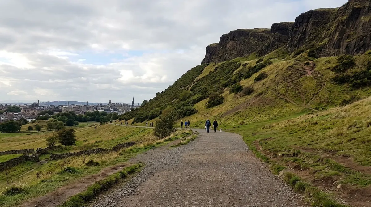 A level gravel path around the base of a grassy volcanic hill with crags above, Holyrood Park, Edinburgh, Scotland