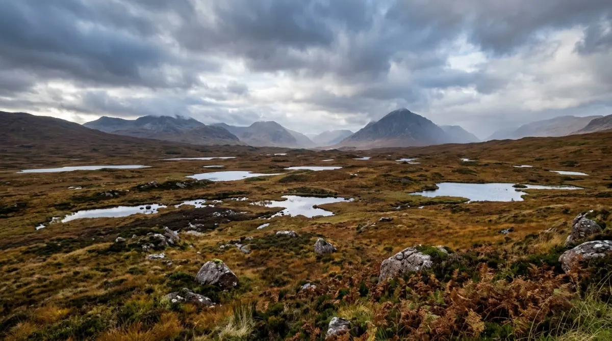 Wide open moorland dotted with small lochans under a big sky and distant mountains, Rannoch Moor, Glencoe, Scotland