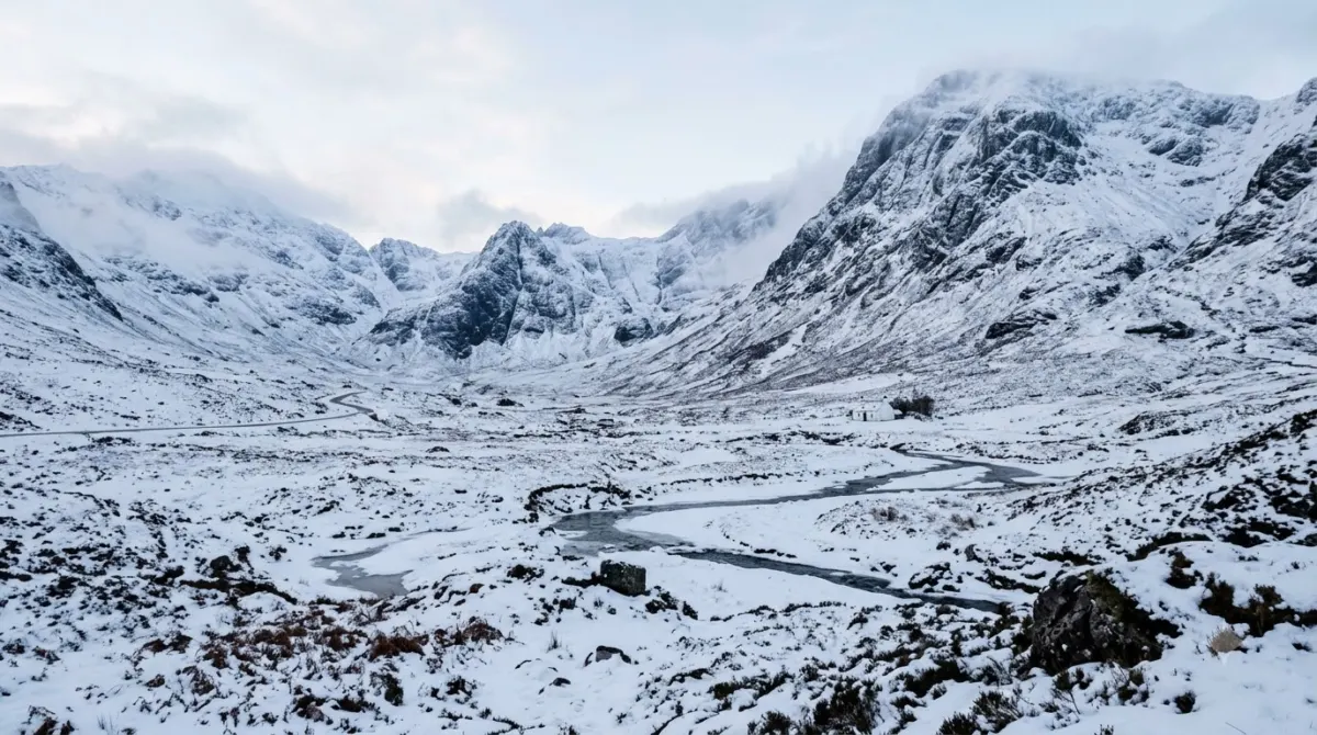 Snow-covered mountains and a white glen floor under a pale winter sky, Glencoe, Scotland