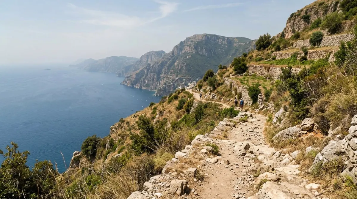 A narrow rocky footpath along a high slope with terraced hillsides and the blue sea far below, Path of the Gods, Positano, Italy