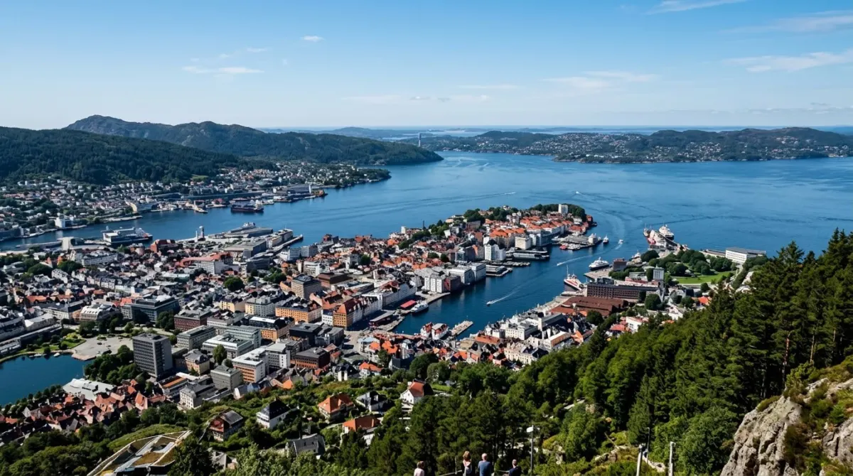 A high viewpoint looking down over the harbour, city rooftops and scattered islands beyond on a clear day, Fløyen, Bergen, Norway