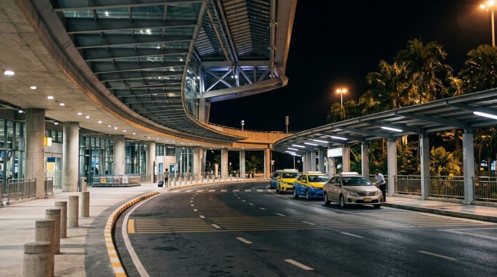 Quiet nighttime arrivals area outside Phuket International Airport with taxis