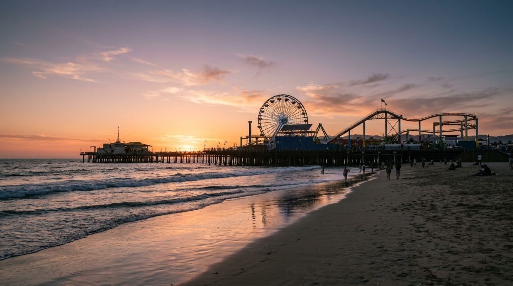 The Santa Monica Pier and Ferris wheel against the Pacific Ocean at sunset