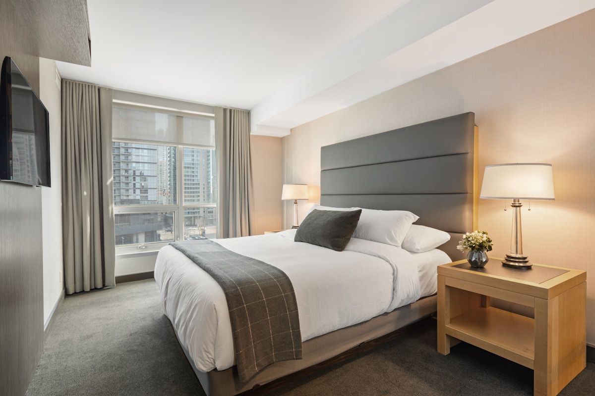Minimalist bedroom with platform bed, neutral linen duvet, and uncluttered wooden nightstand
