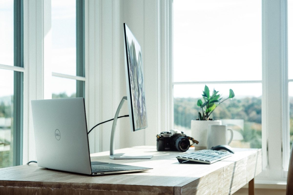 Minimalist home office with white desk, single monitor, and cable-free surface